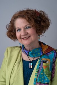 Head Shot of author Anne Perry. She's smiling, her head is tilted and she has curly red hair